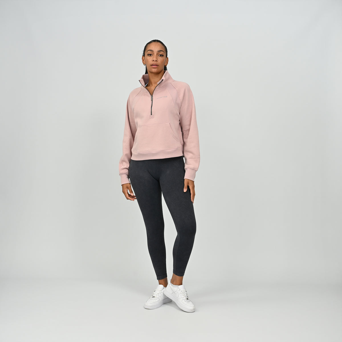 Full body front view of model wearing the dusty pink Hybryd Monterey half zip sweatshirt with kangaroo pocket
