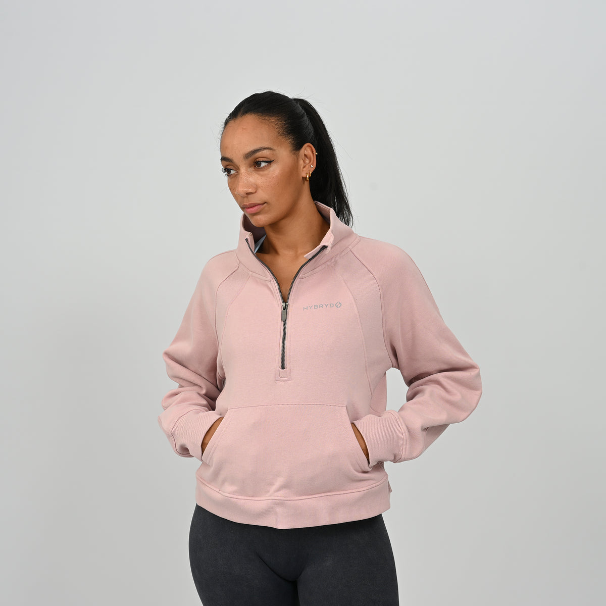 Front view of model wearing the dusty pink Hybryd Monterey high collar half zip sweatshirt with kangaroo pocket   