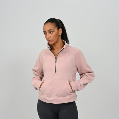 Front view of model wearing the dusty pink Hybryd Monterey high collar half zip sweatshirt with kangaroo pocket   