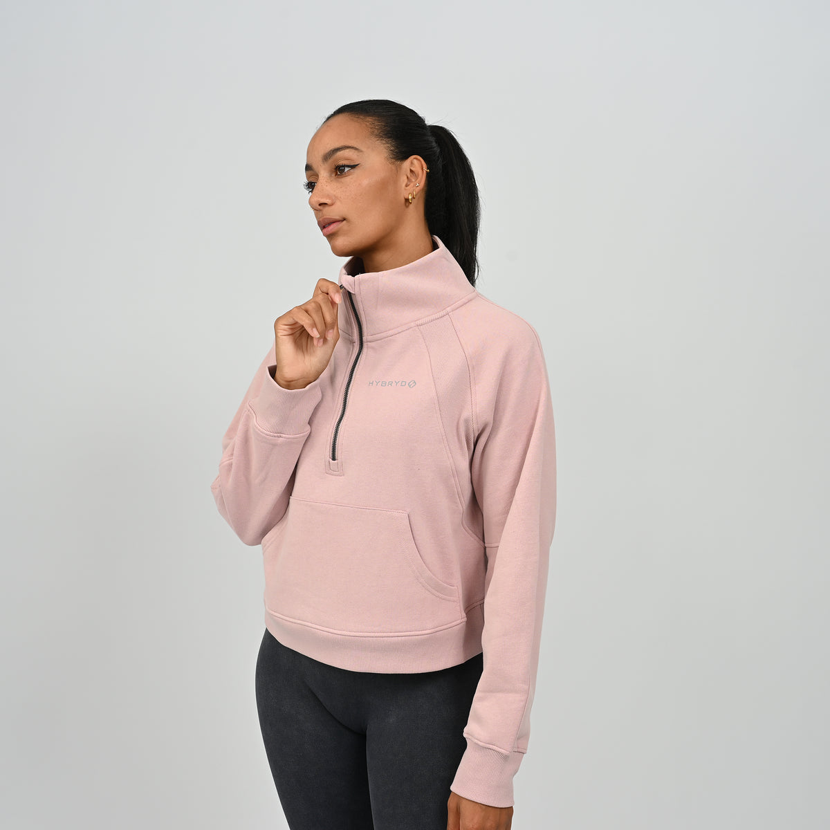 Side profile view of model wearing the dusty pink Hybryd Monterey high collar half zip sweatshirt