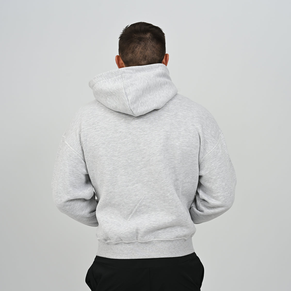 Back view of male model wearing the grey relaxed fit Hybryd Palmer hoodie   