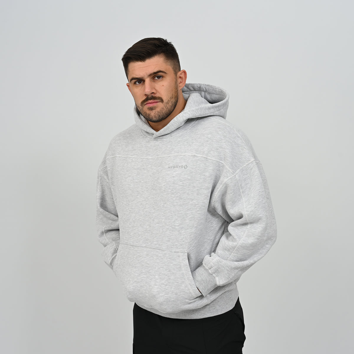 Front view of male model wearing the grey Hybryd Palmer relaxed fit hoodie with kangaroo pocket