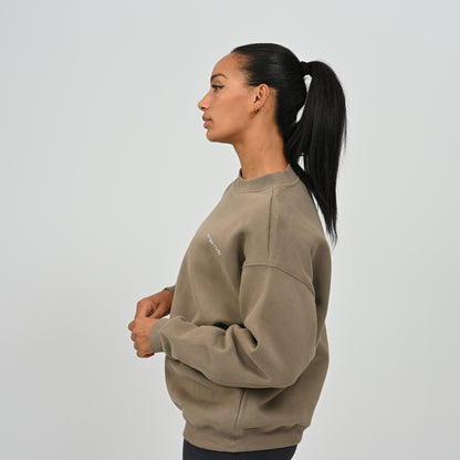 Side profile shot of female model wearing the khaki Women's Jasper fleece-lined relaxed crew neck sweater.